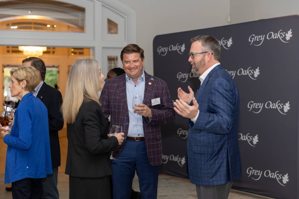 Jim Overbeck standing and talking with two other event guests